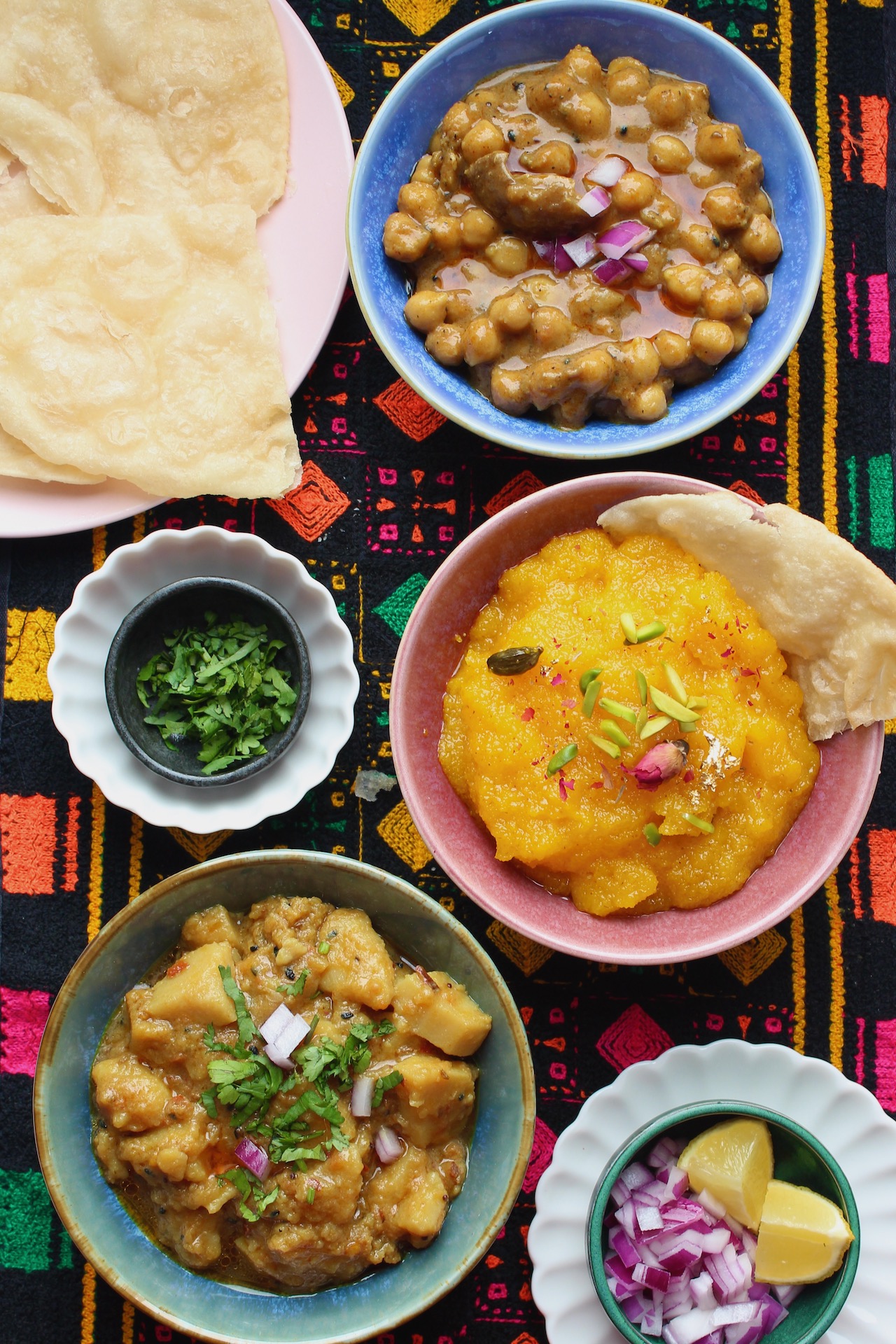 Halwa puri breakfast with fried bread, semolina halwa, and chickpea curry