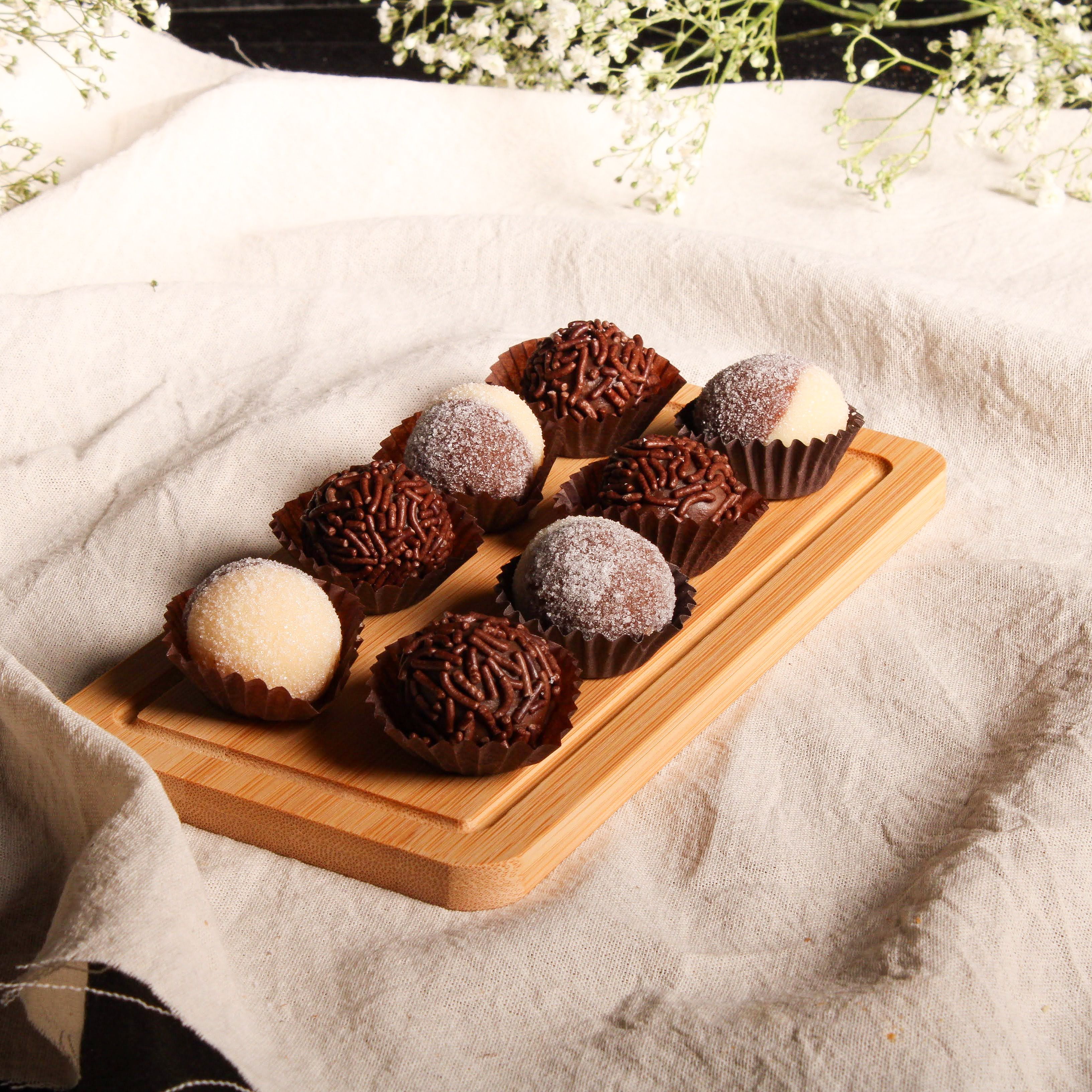Brazilian chocolate brigadeiros coated in chocolate sprinkles and arranged in small paper cases.