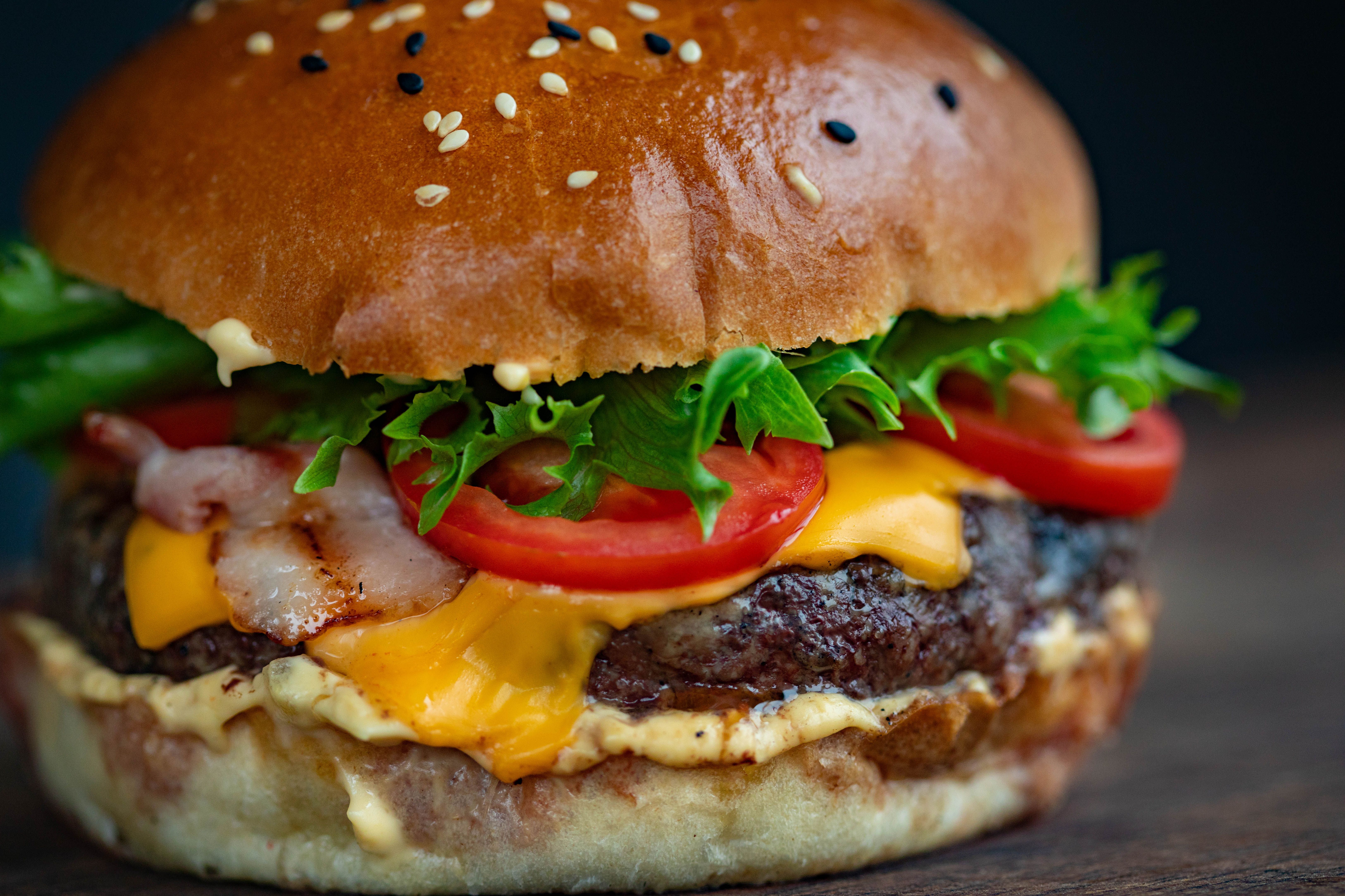 Juicy grilled hamburger patty with a deeply browned crust served in a toasted bun with lettuce, tomato, onion and pickles.