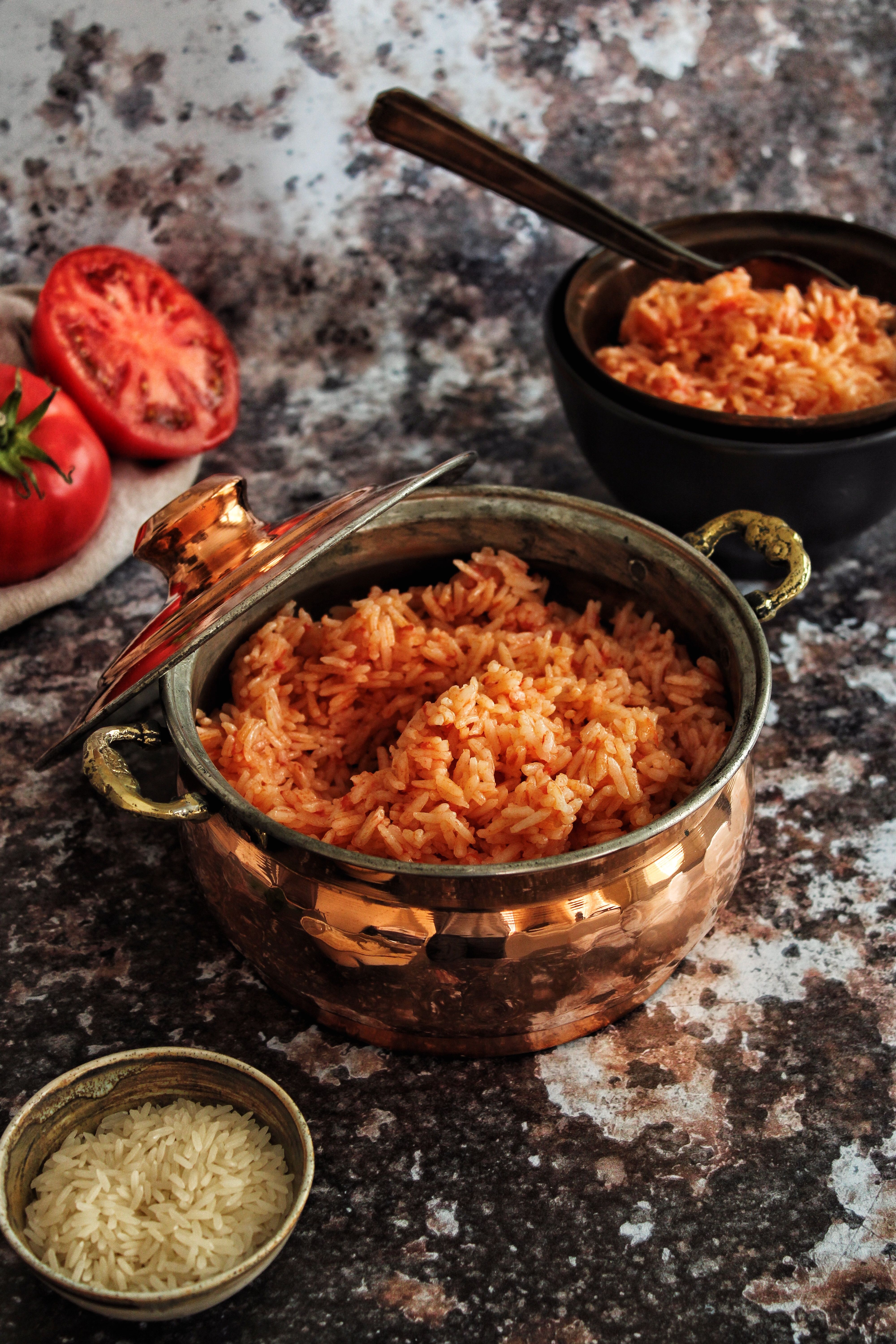 A bowl of homemade tomato rice garnished with fresh coriander leaves and served with yoghurt and crispy papad.