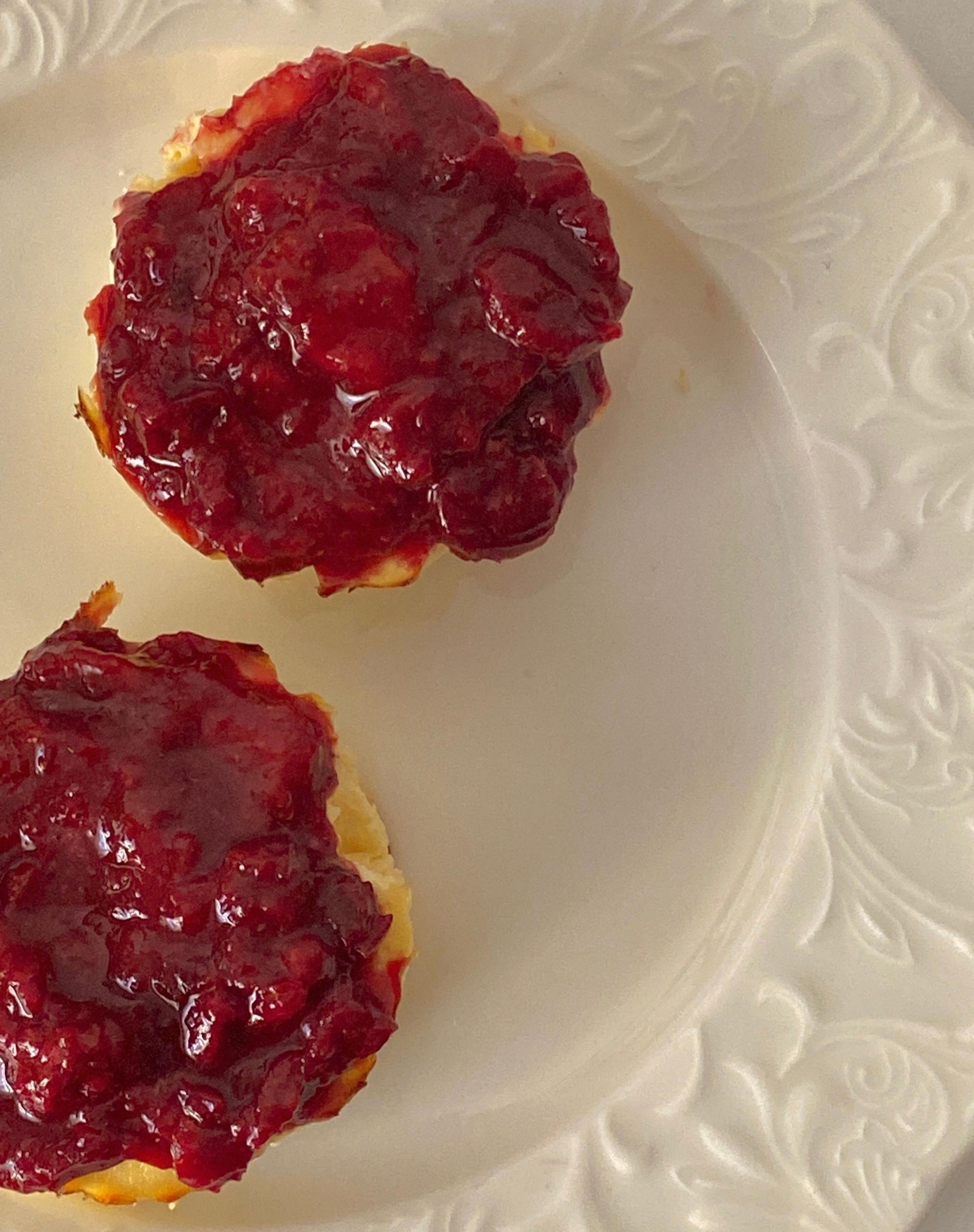 Freshly baked English scones served with clotted cream, strawberry jam, and a pot of hot tea.