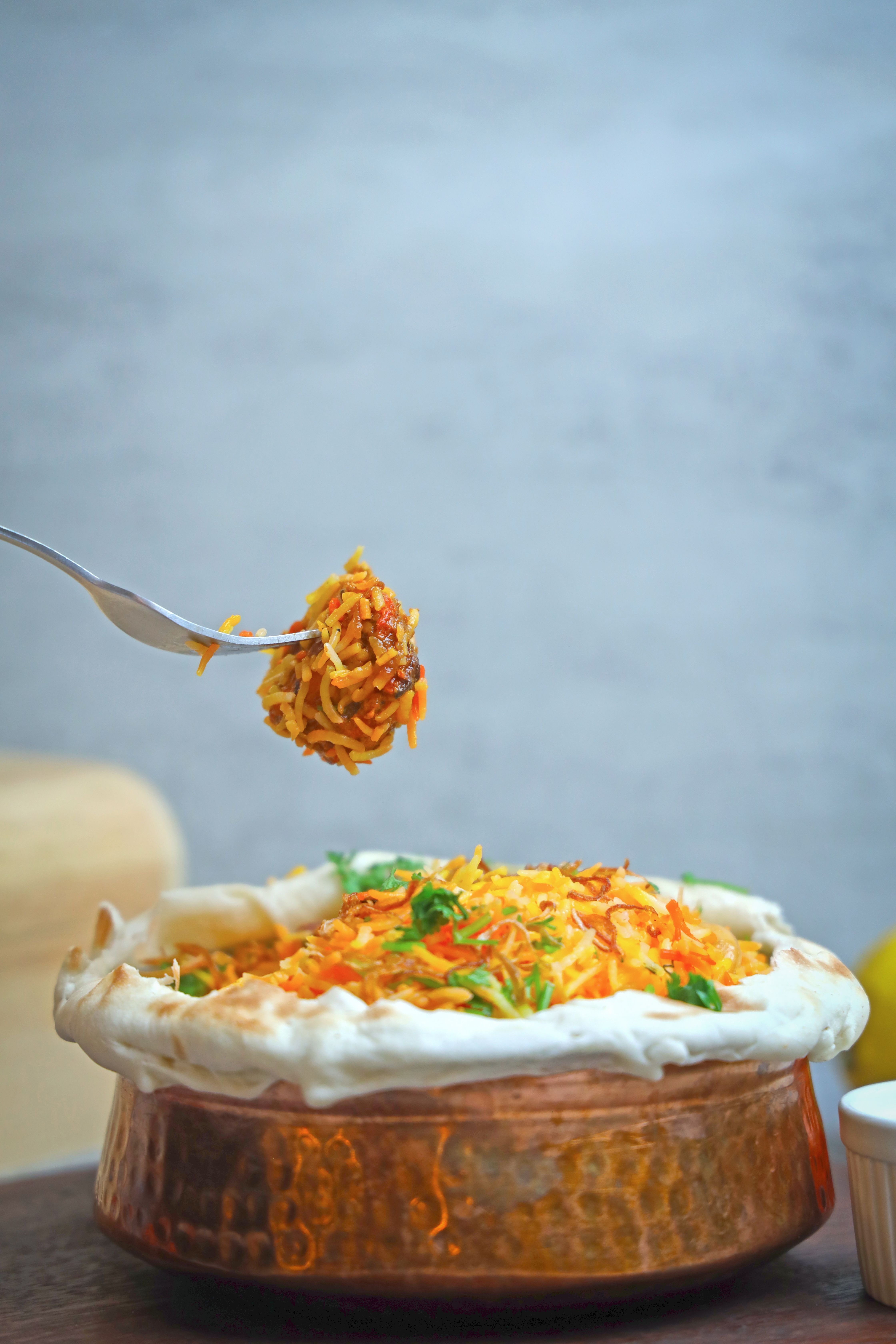 Traditional Pakistani food spread with biryani, daal, roti, nihari, chapli kebab, vegetables, chutney, and kheer