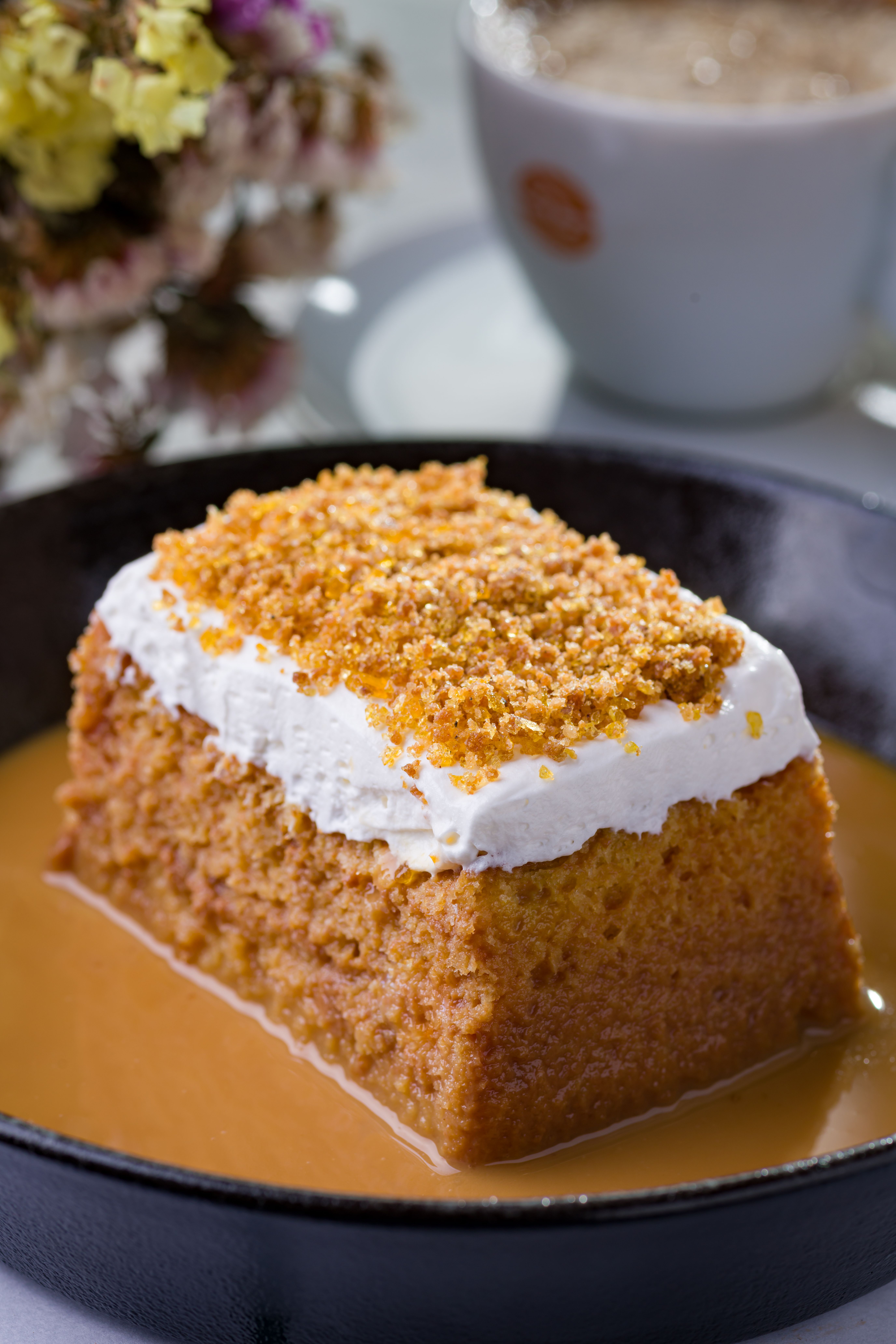 Warm South African malva pudding with a golden apricot sponge soaked in glossy cream sauce.