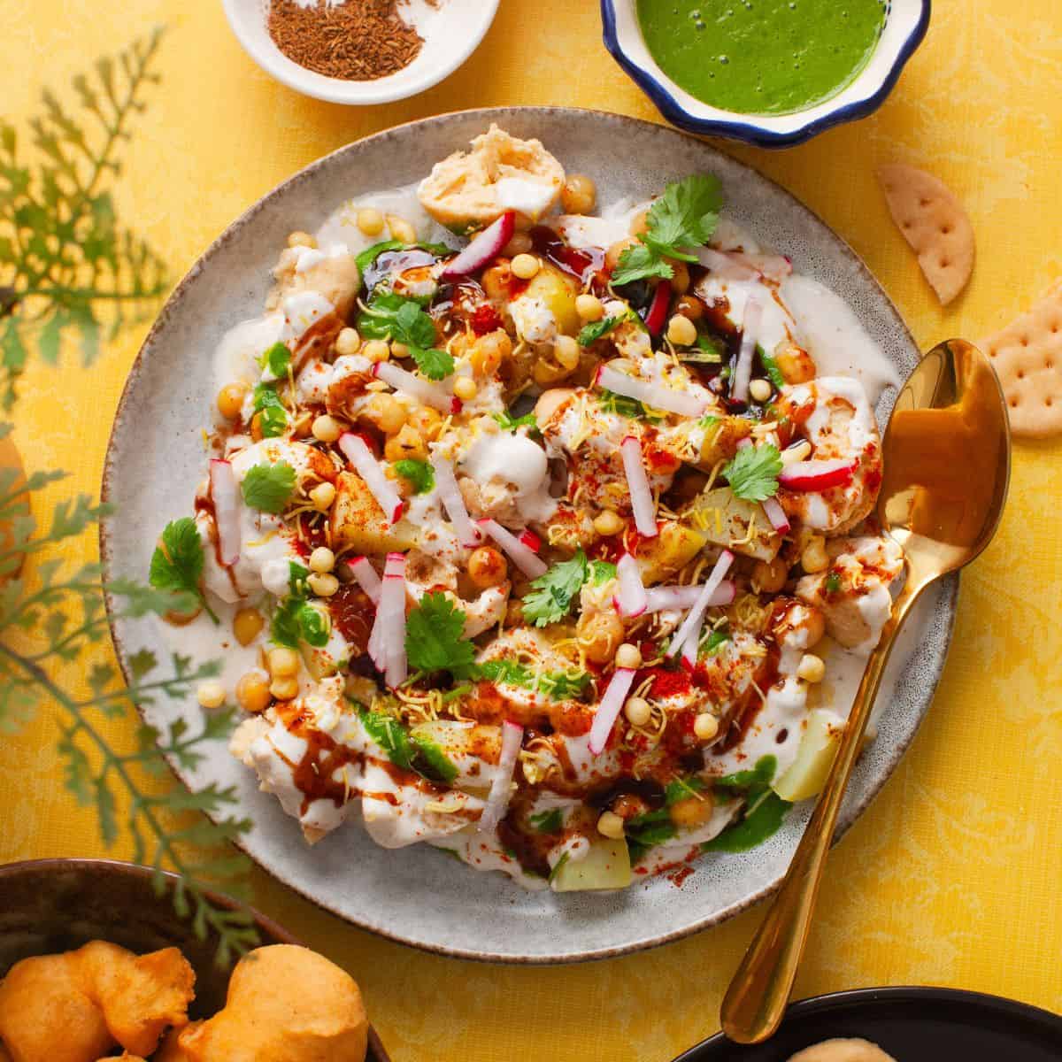 Soft lentil dumplings topped with yogurt, chutneys, and spices