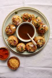 Crispy gol gappa puris filled with chaat and served with chilled tamarind pani.