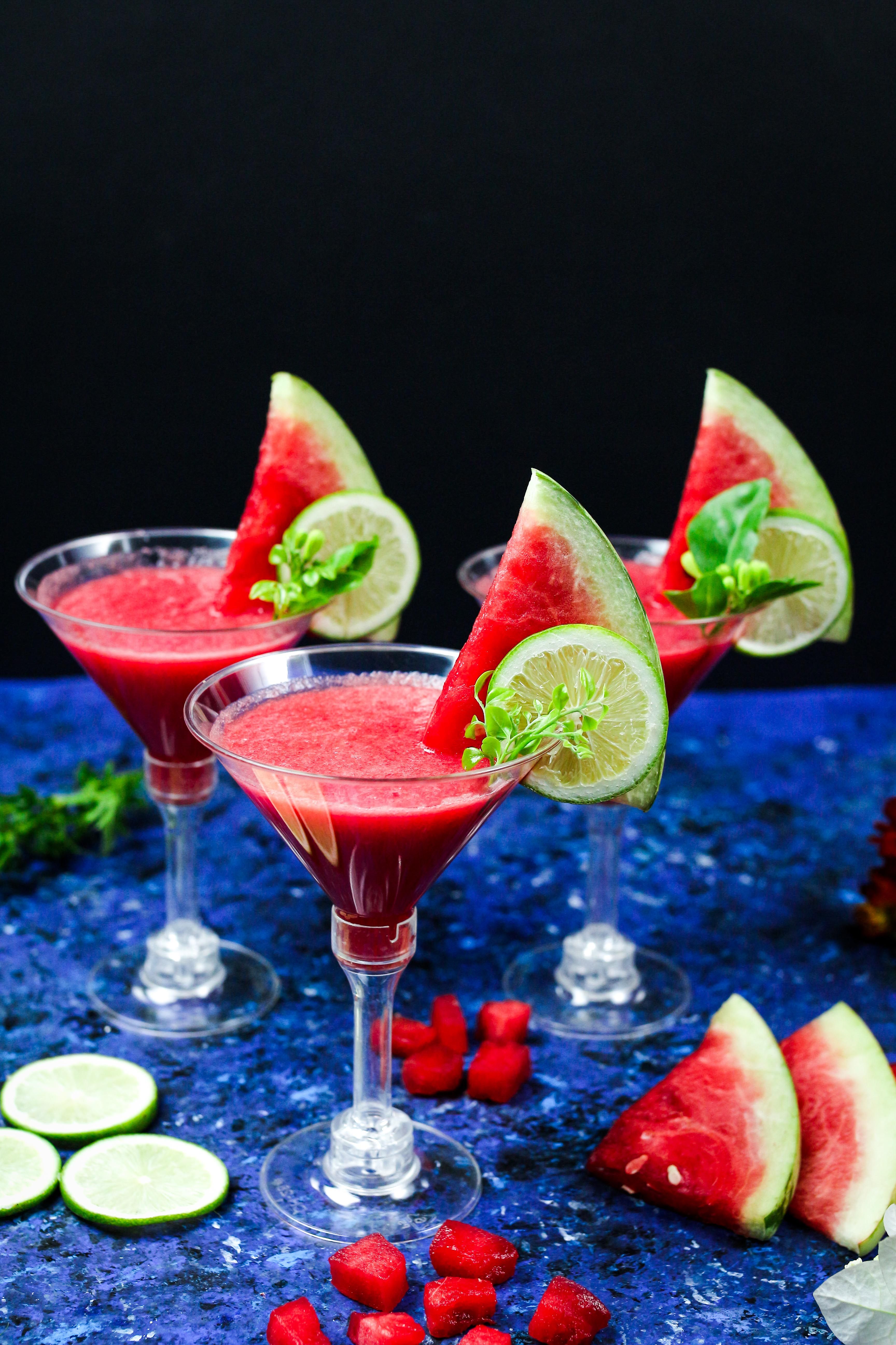 Refreshing watermelon margarita served over ice with lime slices, fresh mint, and a salted rim.