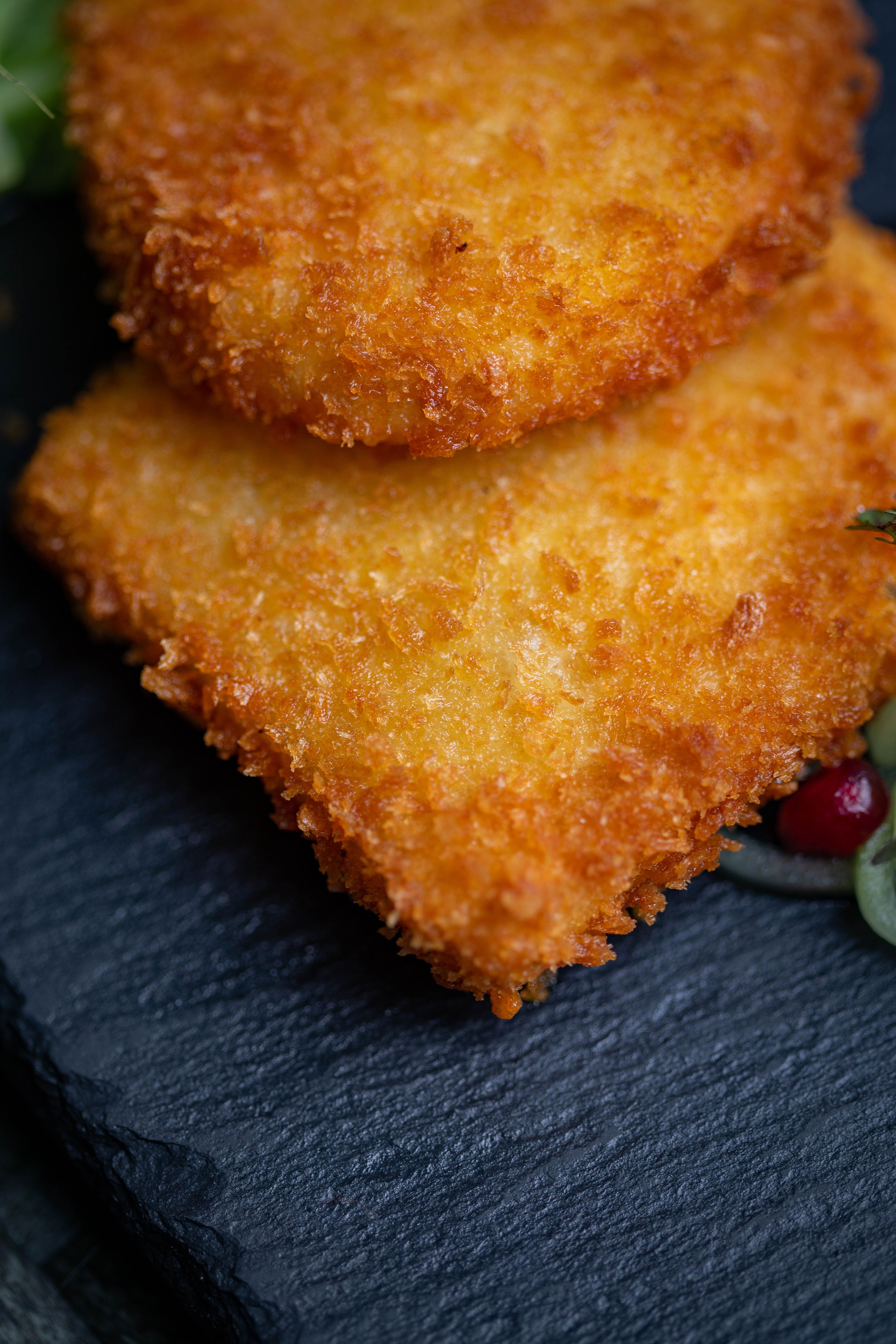 Crispy oval McDonald's-style hash brown patties with deeply golden crusts served beside eggs and ketchup.