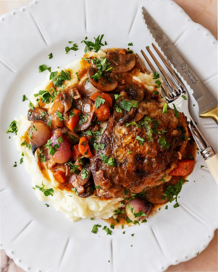 French coq au vin style chicken stew with mushrooms and rich dark sauce