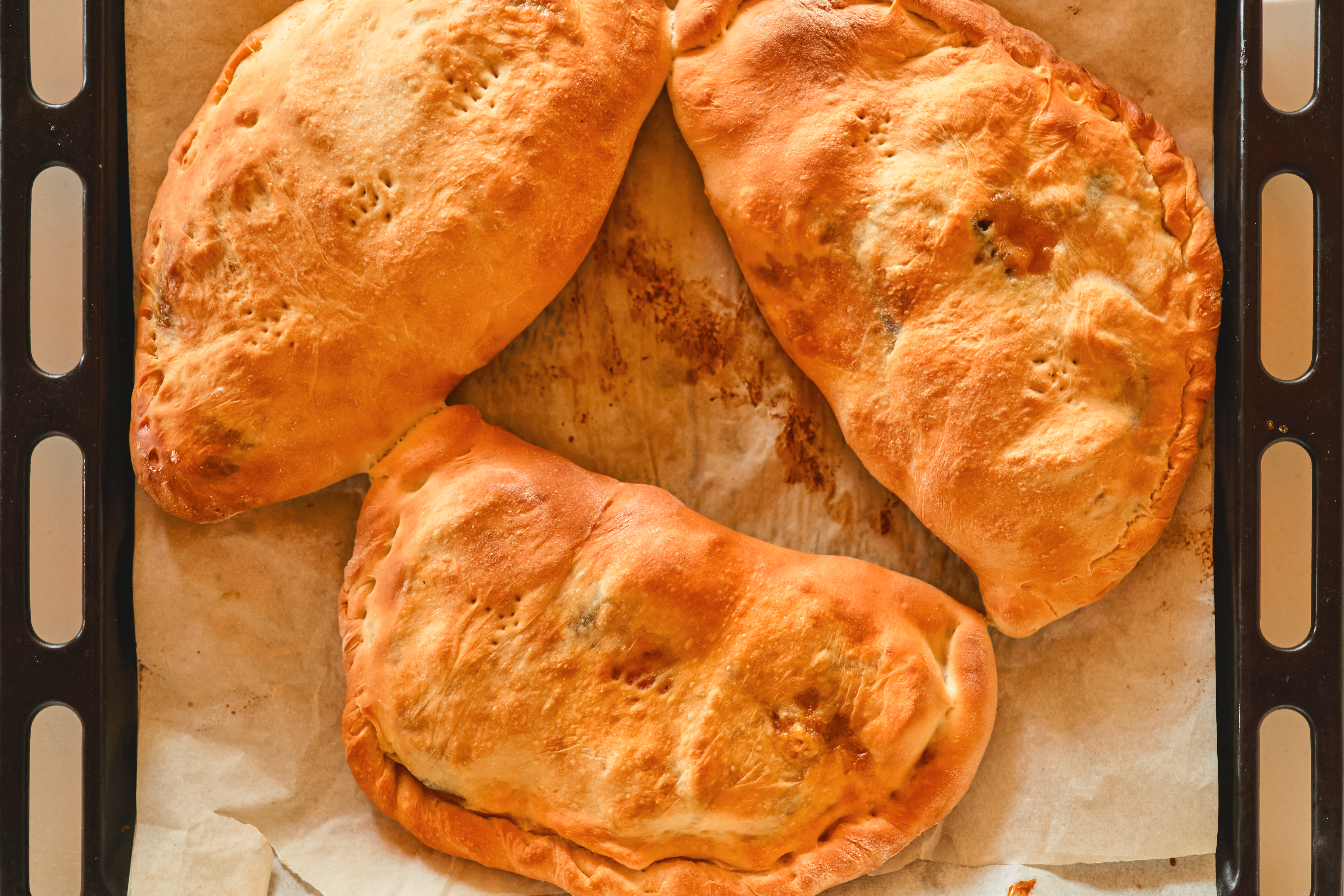 Golden baked beef pasties with a crisp pastry crust, served on a plate.