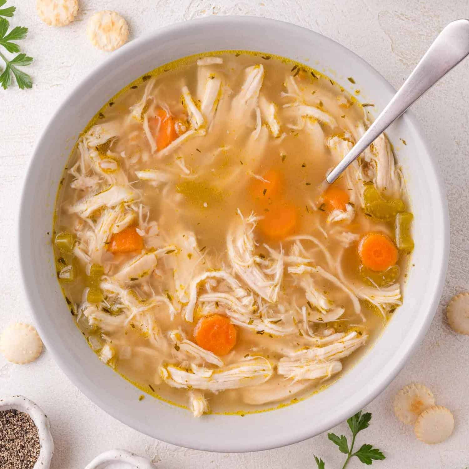 A bowl of hot and sour chicken soup topped with vegetables and delicate egg ribbons.