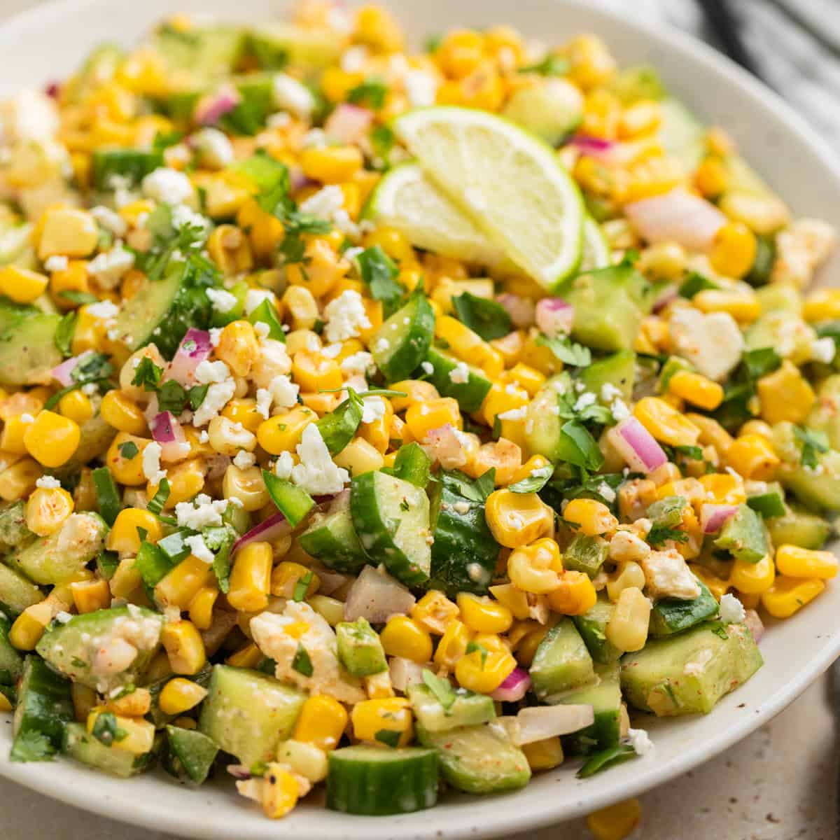 A fresh cucumber corn salad tossed in creamy yogurt dressing with herbs and onion.