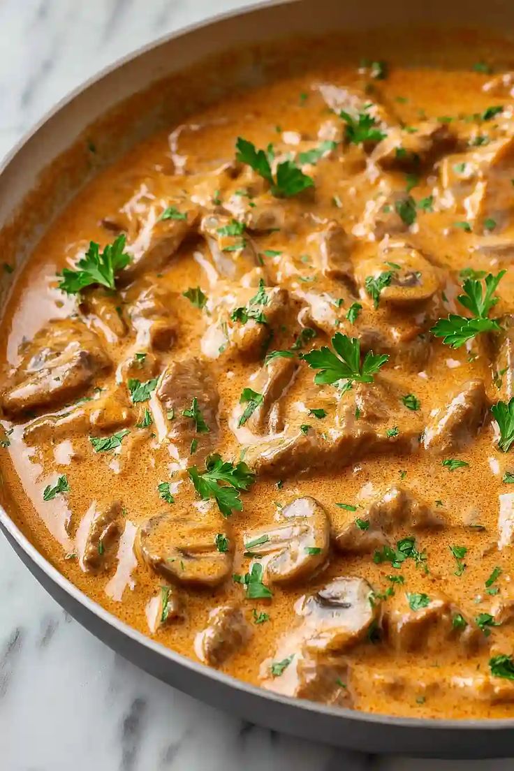 Creamy beef stroganoff with mushrooms served over noodles.
